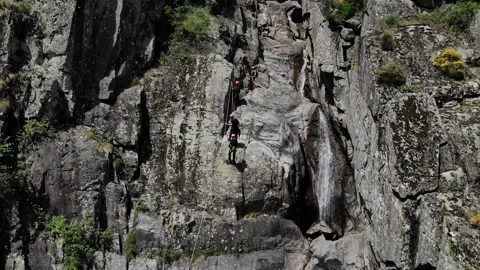 Unrecognizable people abseiling while canyoning. two rock climbers hanging off Stock Footage 201525181