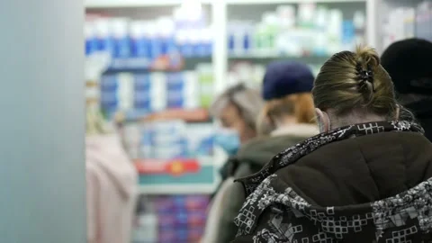 Unrecognizable people are queuing at pharmacy. Line of visitors with face masks Stock Footage 167672667