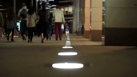Unrecognizable people crowd walking around night city in light of low street Stock Footage 82981472