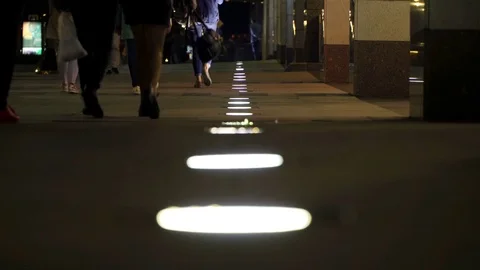Unrecognizable people crowd walking around night city in light of low street Stock Footage 83765136