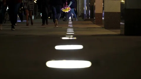 Unrecognizable people crowd walking around night city in light of low street Stock-Footage 84704199
