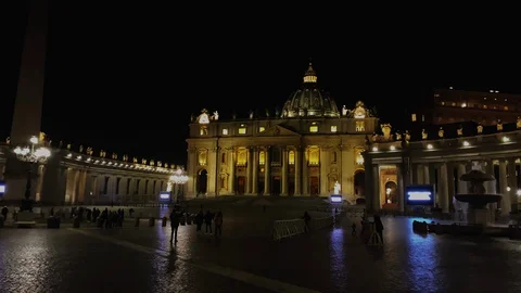 Unrecognizable people walking in the evening in Saint Peter's square in front Stock Footage 129536684