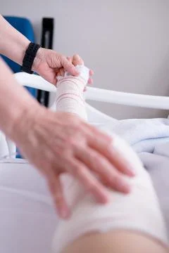 Unrecognizable person checking and treating a leg injury at the a hospital Stock Photos
