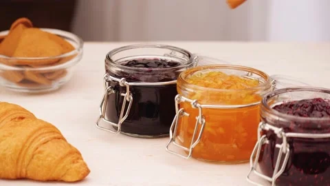 Unrecognizable person dipping cookie into jam Stock Footage 136672201