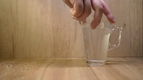 An unrecognizable person moves the mug on the table with his hand Stock Footage 151889775