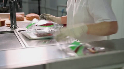 Unrecognizable person packing cut bread at factory indoors Stock Footage 250262506
