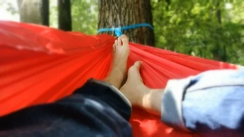 Unrecognizable person resting inside a red hammock in a park 스톡 동영상 91174835