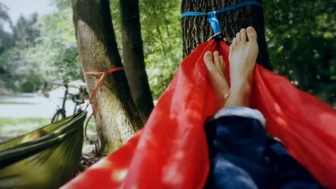 Unrecognizable person resting inside a red hammock in a park 스톡 동영상 91174845
