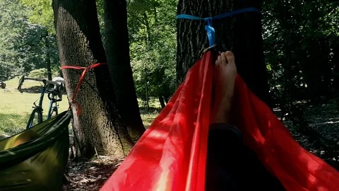 Unrecognizable person resting inside a red hammock in a park Vídeo Stock 91174857