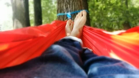 Unrecognizable person resting inside a red hammock in a park 스톡 동영상 91174859