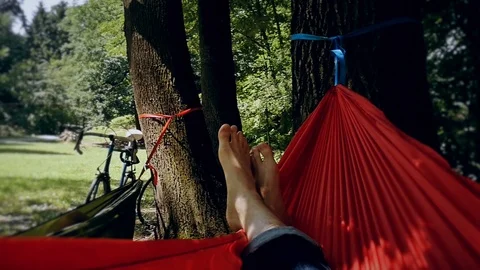 Unrecognizable person resting inside a red hammock in a park Vídeo Stock 91174870