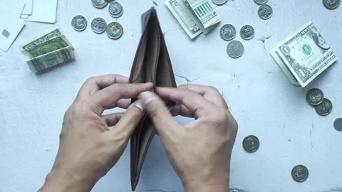 Unrecognizable person shows an empty wallet on gray background in slow motion Stock Footage 332625902
