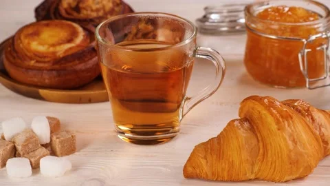 Unrecognizable person taking tea from table with desserts Stock Footage 136671763