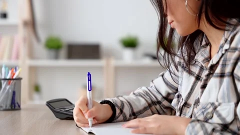 Unrecognizable person using calculator and taking notes. Vídeo Stock 262997260
