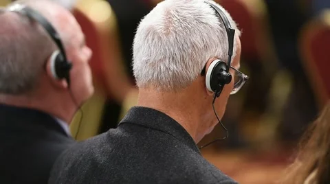 Unrecognizable person using in ear headphones for translation during event Vídeo Stock 68881531