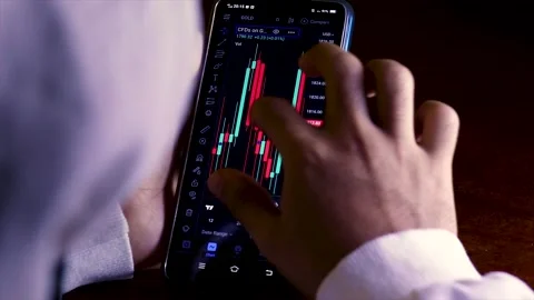 Unrecognizable Person Using a Smartphone And Analyzing Candlestick Chart. Stock Footage 171215220