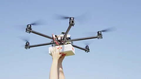 Unrecognizable person's arms getting first aid package off a UAV delivery drone Stock Footage 81189163