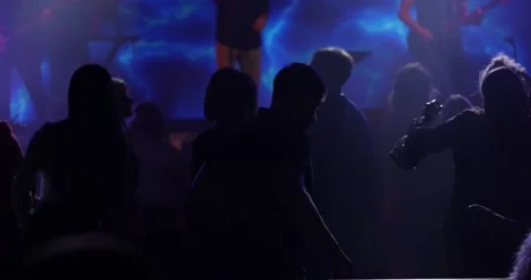 Unrecognizable persons dancing at pop group concert . Silhouettes of beings in Stock Footage 154556749