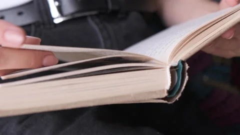 Unrecognizable Person's Hand reading a book and holding fingers along the lines Stock Footage 135797753