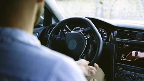 Unrecognizable person's hands holding steering wheel while driving modern Stock Footage 200837498