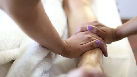 Unrecognizable physiotherapist making a tibia massage to a female patient. Stock Footage 175439135