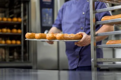Unrecognizable professional baker at bakery with bread baguette 스톡 사진