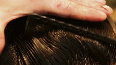 Unrecognizable professional barber combing wet hair and smoothes them by hand Video stock 98091179