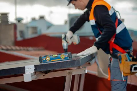 Unrecognizable Professional worker installing solar panels on a house roof Foto stock