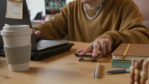 Unrecognizable Programmer Playing with Fingerskate Stock-Footage 317337868