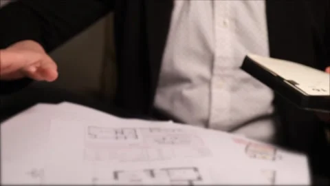 An unrecognizable realtor worker at the table sorts through papers and documents Stock Footage 312272172