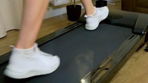 Unrecognizable runner slowing stride on treadmill and stopping after indoor Stock Footage 340905429