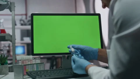Unrecognizable scientist typing green screen pc holding test tube in lab closeup Stock Footage 254621360