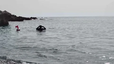 An unrecognizable scuba diver puts on a mask to dive in the Tyrrhenian Sea. Stock-Footage 197142078