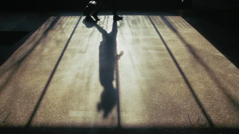 Unrecognizable Silhouette of Man with Suitcase Walking Through Sunlit Parking Vídeo Stock 335473794
