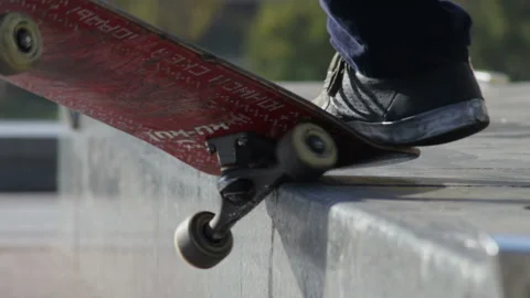 Unrecognizable skater does the grind trick crooked on granit ledge, closeup view Stock Footage 96830005