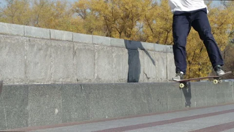 Unrecognizable skater doing trick nose slide on the street ledge of monument Stock Footage 96828538