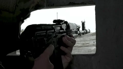 An unrecognizable soldier aims from the window, the cracks of the shelter at the Stock Footage 244872344