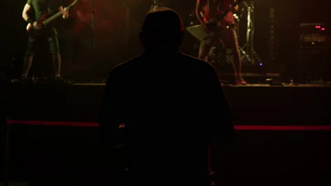 Unrecognizable Sound Engineer adjusts sound for rock concert in large event hall Stock Footage 218340336