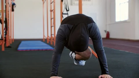 Unrecognizable sportive man is doing mountain climbers cardio exercise in gym. Видео 234549493