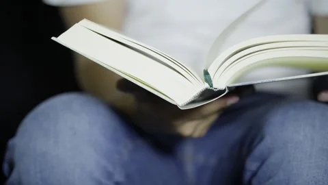 Unrecognizable Student Holding A Book And Starting To Turn The Pages Stock Footage 272477720