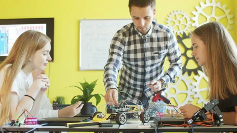Unrecognizable students assembling car in robotics class Stock Footage 140761257