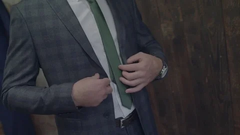Unrecognizable stylish man dresses buttoning checked jacket and straightening it Stock Footage 72601522