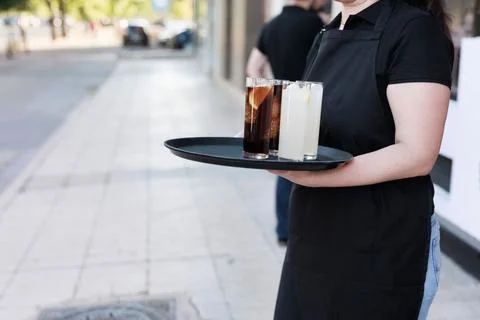 Unrecognizable waitress working on restaurant holding drink. latin woman worker Stock Photos