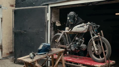 Unrecognizable Welder Customizing Motorcycle in Open Garage Workshop Video stock 312704565