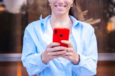 Unrecognizable woman browsing the internet using mobile device outdoors. Stock Photos