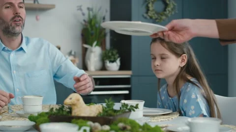 Unrecognizable woman cutting easter cake and passes a piece to the family in the Stock Footage 170875603