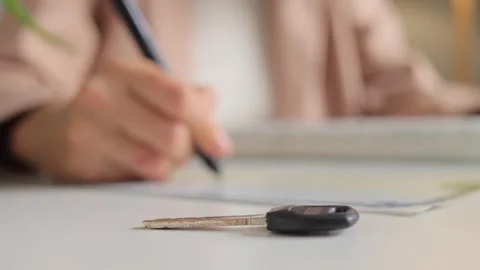 Unrecognizable woman engaged in document writing, real estate agent carries out Stock Footage 253885346