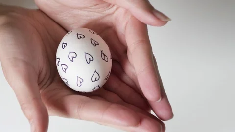 Unrecognizable woman holding an egg with a pattern in her hands. Easter eggs 스톡 동영상 108196369