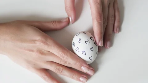 Unrecognizable woman holding an egg with a pattern in her hands. Easter eggs 스톡 동영상 108196821