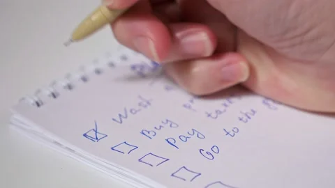 Unrecognizable woman marks completed tasks by ticking the checkboxes Stock Footage 148115586
